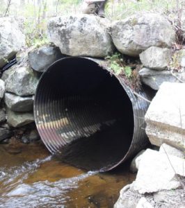 Photo of an old, metal pipe culvert that is barrier to brook trout passage. 