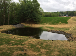 A detention pond holds stormwater runoff from a nearby roadwork project that required an AoT permit in Nashua, NH